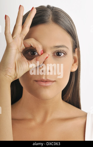 Weibliche junger Erwachsener, durch Finger Loch suchen Stockfoto