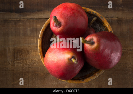 Anjou rote Birnen in rustikalen Schüssel auf rustikalen Holz-Schuss von oben Stockfoto