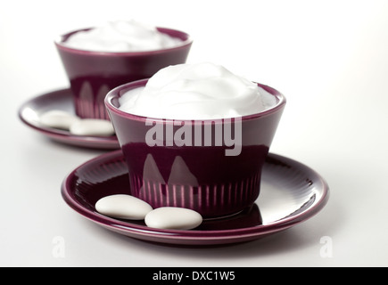 cremige Joghurt im Retro-Stil-Becher mit weißen Bonbons auf morgen Tisch Stockfoto