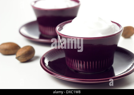 cremige Joghurt und Nüssen auf weißen Tisch Stockfoto