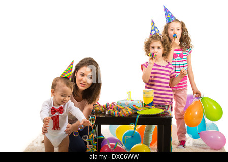 Mutter und Kinder mit party und feiern junge ersten Geburtstag, Kleinkind, Seifenblasen zu fangen versuchen Stockfoto