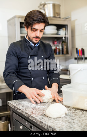 Professionelle Köchin oder Koch in einer Großküche warf Teig bei der Herstellung von Gebäck für Desserts im Restaurant oder im hotel Stockfoto