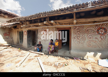 Eine Stammes-Familie sitzt außerhalb ihrer Schlamm Haus gemalt. Lodha Kaste. Bhilwara Dorf, Bezirk Hazaribaug, Jharkhand, Indien Stockfoto