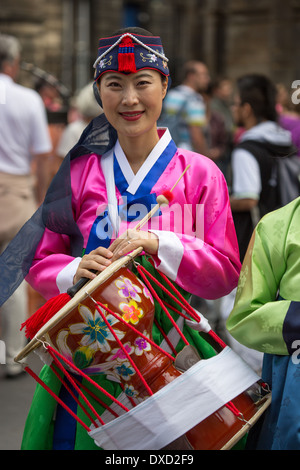 Akteure aus der koreanischen Modl Theatre Company Förderung gibt es Leistung auf Edinburghs Royal Mile während des Edinburgh Fringe Stockfoto