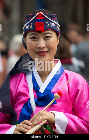 Akteure aus der koreanischen Modl Theatre Company Förderung gibt es Leistung auf Edinburghs Royal Mile während des Edinburgh Fringe Stockfoto