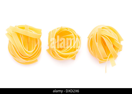 Essen: getrocknete italienische Pasta, Fettuccine Nester, isoliert auf weißem Hintergrund Stockfoto
