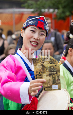 Akteure aus der koreanischen Modl Theatre Company Förderung gibt es Leistung auf Edinburghs Royal Mile während des Edinburgh Fringe Stockfoto