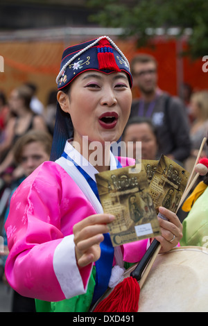 Akteure aus der koreanischen Modl Theatre Company Förderung gibt es Leistung auf Edinburghs Royal Mile während des Edinburgh Fringe Stockfoto