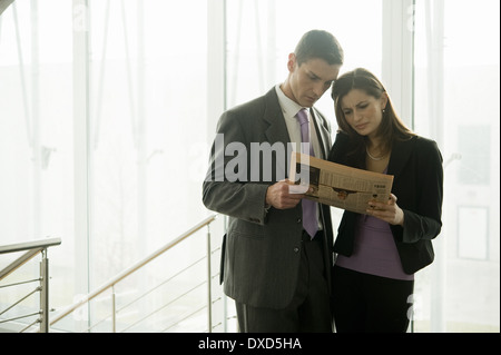 Unternehmer und Unternehmerin Finanzzeitung betrachten Stockfoto