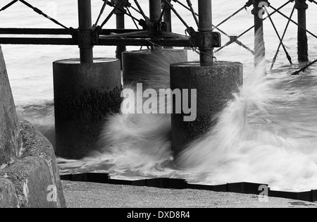 Wellen, die unter dem Pier bei Cromer im Winter in Norfolk, England Stockfoto