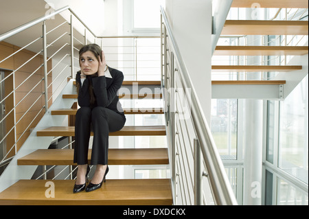 Geschäftsfrau auf Büro Treppe hielt ihren Kopf Stockfoto