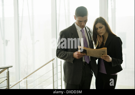 Unternehmer und Unternehmerin Finanzzeitung betrachten Stockfoto