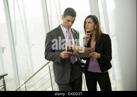 Unternehmer und Unternehmerin Finanzzeitung betrachten Stockfoto