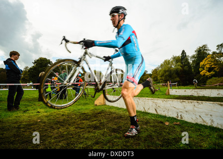 Konkurrent clearing Barriere Rapha Super Cross Querfeldein-Rennen in Broughton Hall in der Nähe von Skipton North Yorkshire England Stockfoto