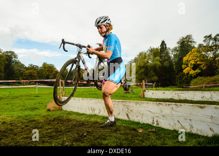 Konkurrent clearing Barriere Rapha Super Cross Querfeldein-Rennen in Broughton Hall in der Nähe von Skipton North Yorkshire England Stockfoto