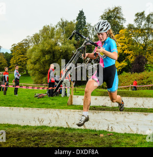 Konkurrent clearing Barriere Rapha Super Cross Querfeldein-Rennen in Broughton Hall in der Nähe von Skipton North Yorkshire England Stockfoto