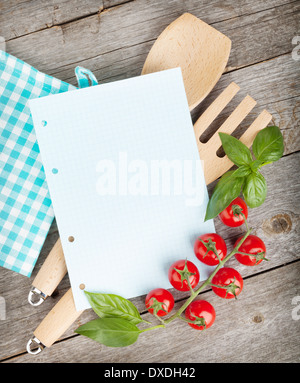 Leere Notizblatt Papier für Ihre Rezepte mit Tomaten und Basilikum auf Holztisch Stockfoto