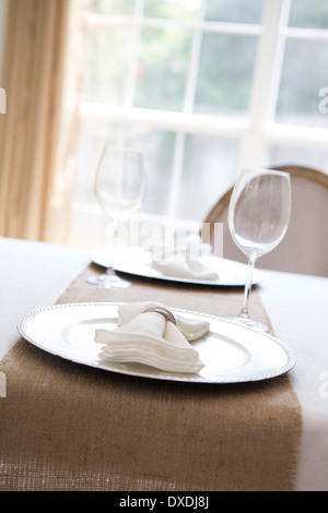 Einfache und elegante Gedeck für zwei Personen mit Platte Ladegerät und Serviette Stockfoto