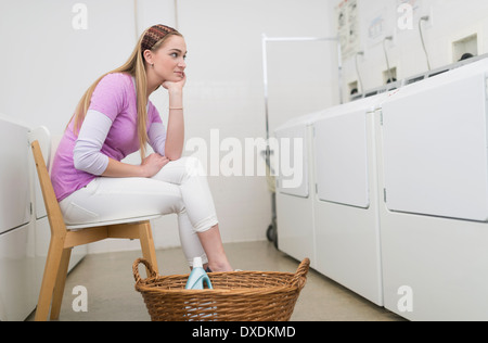 Frau wartet im Waschsalon Stockfoto