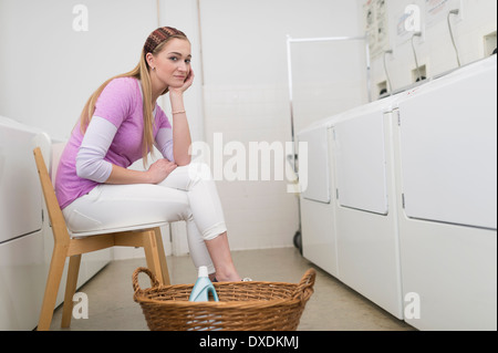 Frau wartet im Waschsalon Stockfoto