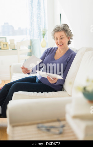 Frau sitzt auf Trainer Briefe lesen Stockfoto