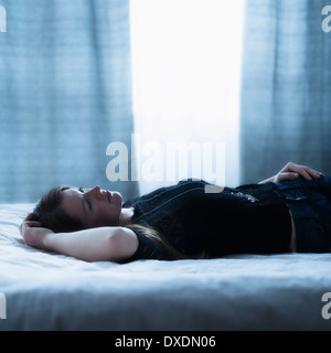 Portrait der schönen Frau auf dem Bett liegend Stockfoto