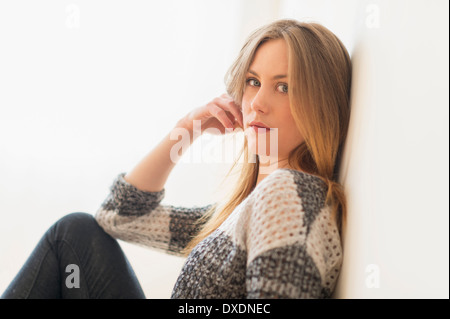 Porträt von attraktiven jungen Frau Wand sitzen Stockfoto