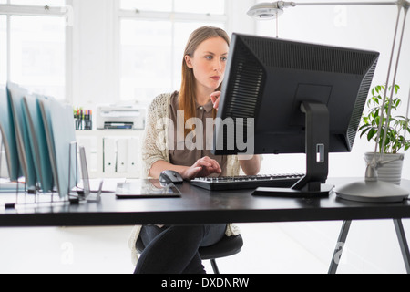 Porträt der jungen Frau, die Arbeiten am Computer im Büro Stockfoto