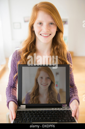 Porträt von Mädchen (12-13) Holding laptop Stockfoto