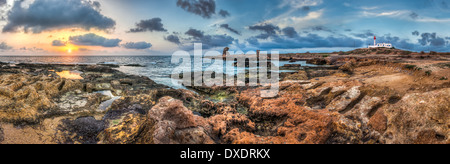 Sonnenuntergang über dem Meer und die felsige Küste mit antiken Ruinen Stockfoto