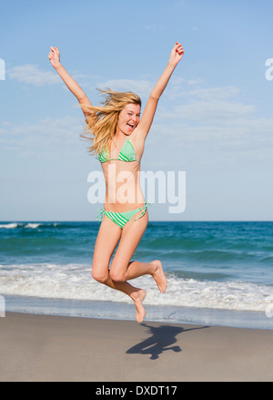 Junge Frau springt auf Strand, Jupiter, Florida, USA Stockfoto