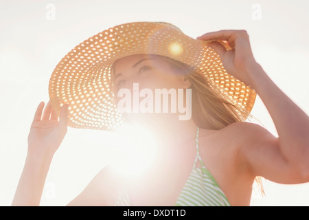 Junge Frau in Sonnenhut am Strand Stockfoto