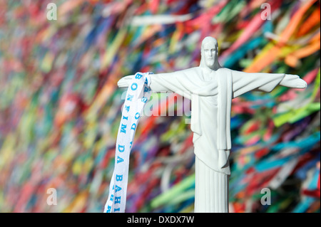 Christus der Erlöser religiöse Andenken vor Wand der bunten brasilianischen wünschen Bänder in Salvador Bahia Brasilien Stockfoto