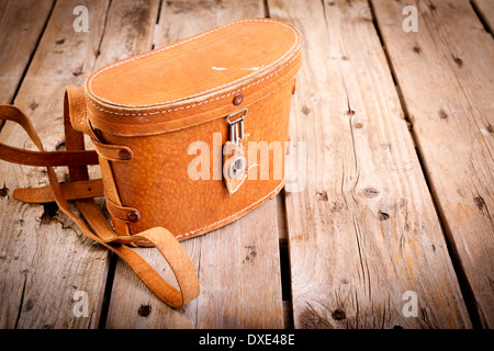 Alte Vintage Ledertasche mit Lederband auf Holztisch Stockfoto