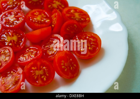 Cherry-Tomaten auf einem Teller, in zwei Hälften geschnitten. Schließen Sie die Ansicht. Stockfoto
