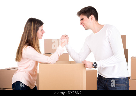 Junges Paar Armdrücken über Boxen, Umzug in neue Haus Wohnung Stockfoto