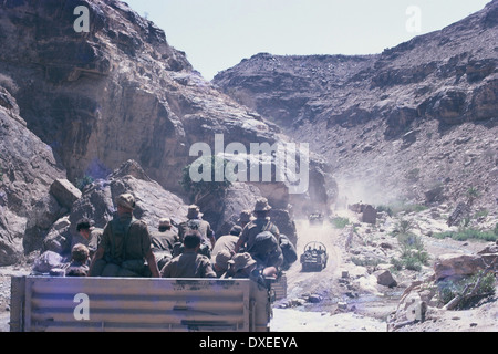 Britische Soldaten fahren in Armee-LKWas auf einer abgestuften Straße durch ein Wadi in der Wüste, in Notfällen Aden 1967 Stockfoto