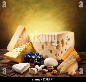 Verschiedene Arten von Käse über alten Holztisch. Stockfoto