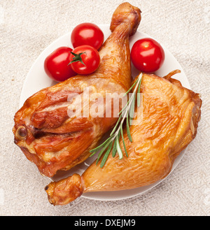 Geräuchertem Huhn mit Tomaten auf einem weißen Teller. Stockfoto