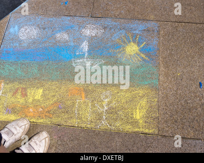 Childs Kreidezeichnung auf Asphalt mit weißen Schuhen in Ecke Cromer Norfolk England Stockfoto