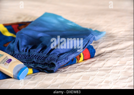 Badeshorts, Strandtuch und hohem Lichtschutzfaktor Sonnencreme. Stockfoto