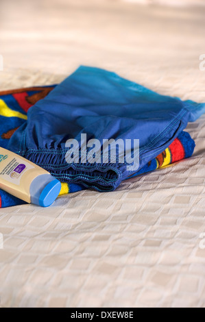 Badeshorts, Strandtuch und hohem Lichtschutzfaktor Sonnencreme. Stockfoto