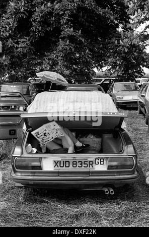 Ein kleines Mädchen liest einen Comic im Kofferraum, hinten im Auto ihrer Eltern. Windsor, Berkshire, 1978 1970er Jahre, UK HOMER SYKES Stockfoto