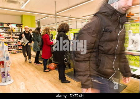 Shopper beim Self-service Check out Kassen in der Genossenschaft Shop, Old Street, London EC1V, UK. Stockfoto