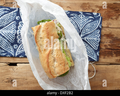 Draufsicht der Hähnchen-Salat-Sandwich auf Baguette in Wachspapier, Studioaufnahme Stockfoto