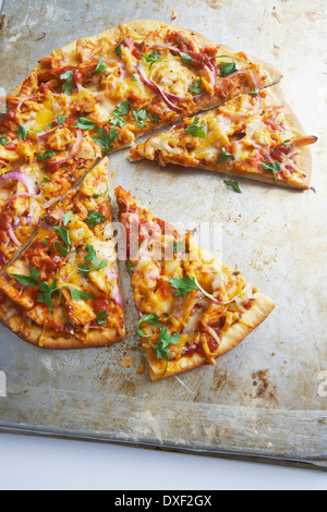 Draufsicht der geschnittenen Pizza mit Huhn und roten Zwiebeln, Studioaufnahme Stockfoto