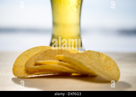 Pint Bier. Ein schäumendes Glas Bier und Chips im Hintergrund Stockfoto