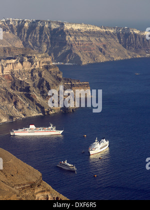 Kreuzfahrtschiffe ankern unter den Klippen in der vulkanischen Caldera von Santorini, Griechenland. Stockfoto