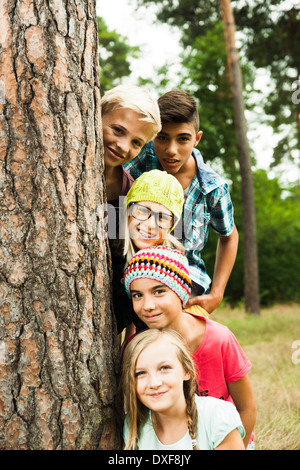 Porträt der Gruppe von Kindern posiert neben Baum im Park, Deutschland Stockfoto