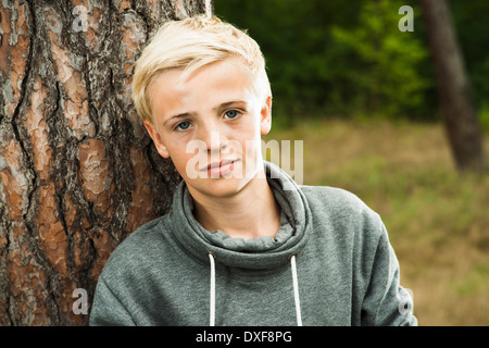 Close-up Portrait jungen stehen vor Baum im Park, Blick in die Kamera, Deutschland Stockfoto